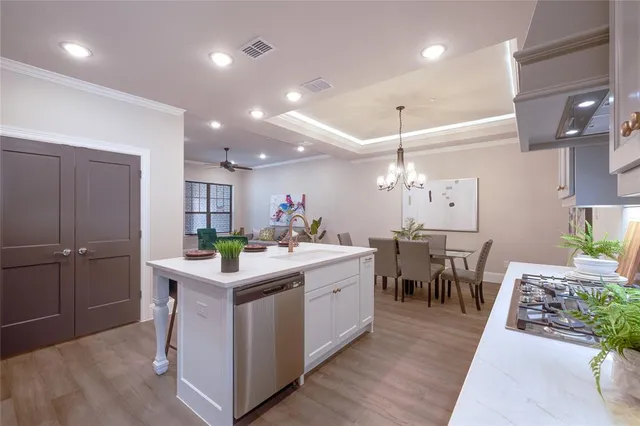 a kitchen with white cabinets and dining table