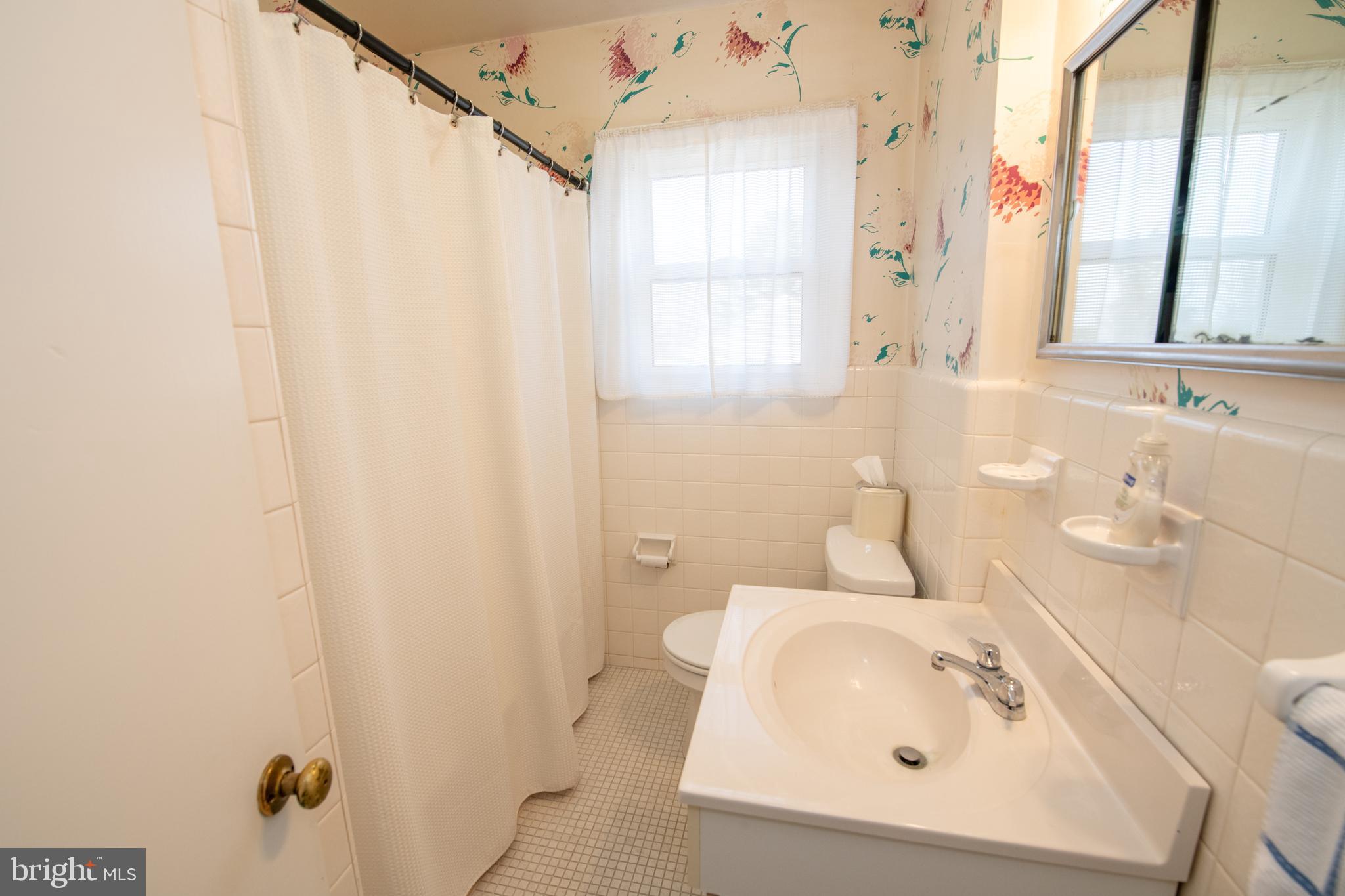 8810 Tyson Road Glenside, PA 19038 - Photo 24 of 53 a bathroom with a sink a mirror and a shower curtain