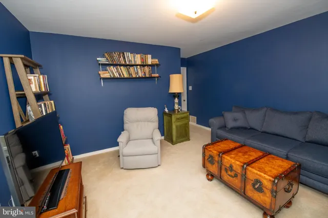 a living room with furniture a flat screen tv and a window