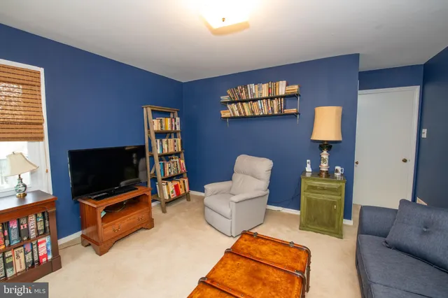 a living room with furniture a flat screen tv and a window
