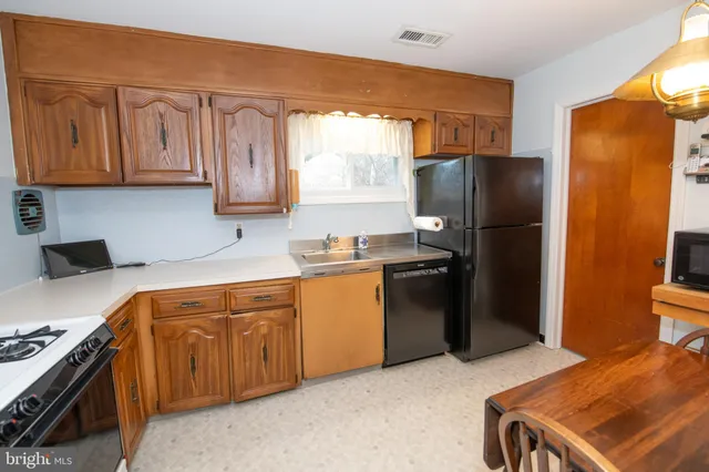 a kitchen with stainless steel appliances granite countertop a sink a stove and a refrigerator
