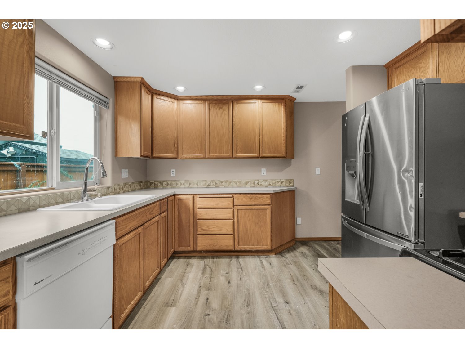 52269 Southeast Tyler Street Scappoose, OR 97056 - Photo 7 of 21 a kitchen with stainless steel appliances granite countertop a refrigerator a sink dishwasher a stove with wooden cabinets and floor