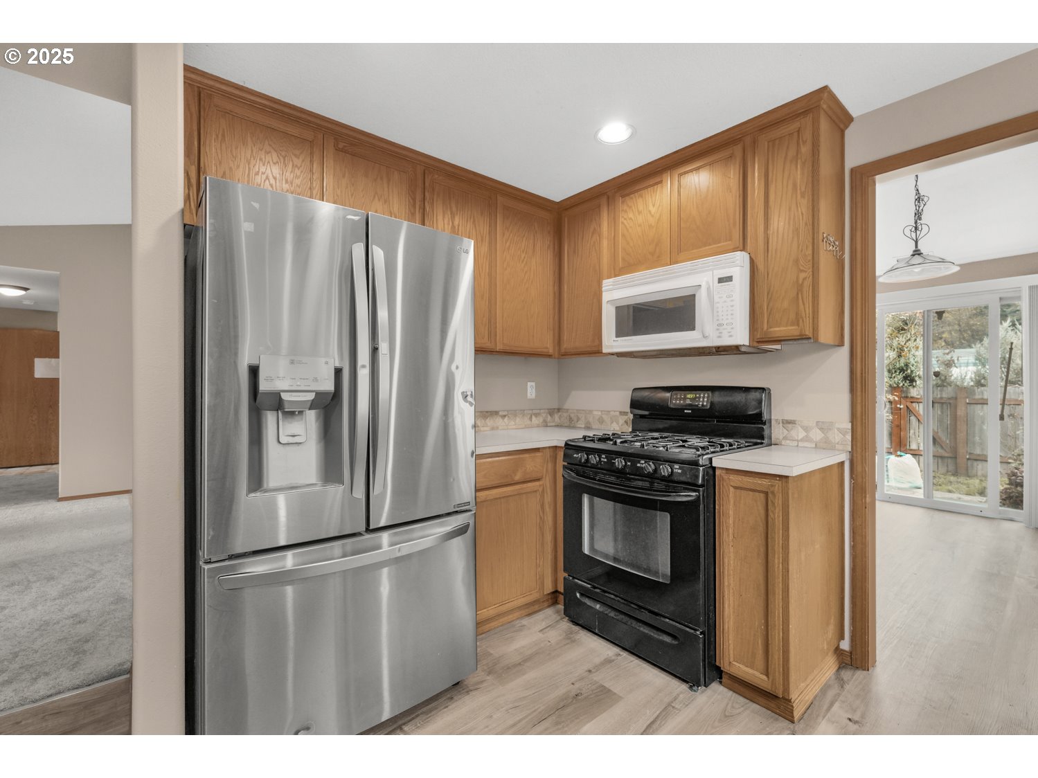 52269 Southeast Tyler Street Scappoose, OR 97056 - Photo 8 of 21 a kitchen with stainless steel appliances granite countertop a stove a refrigerator and a microwave