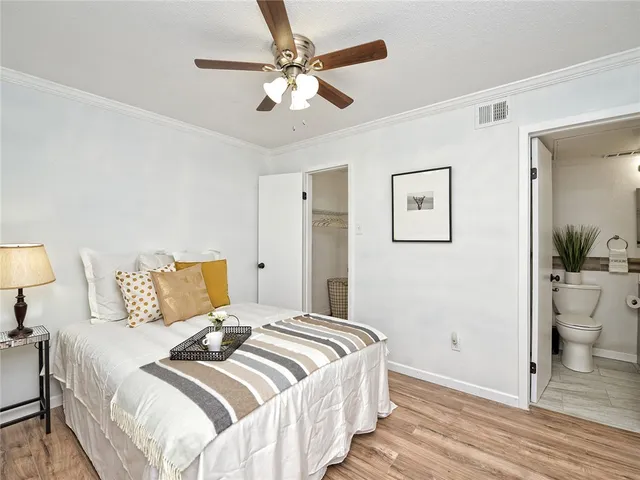 a bedroom with a large bed and a chandelier