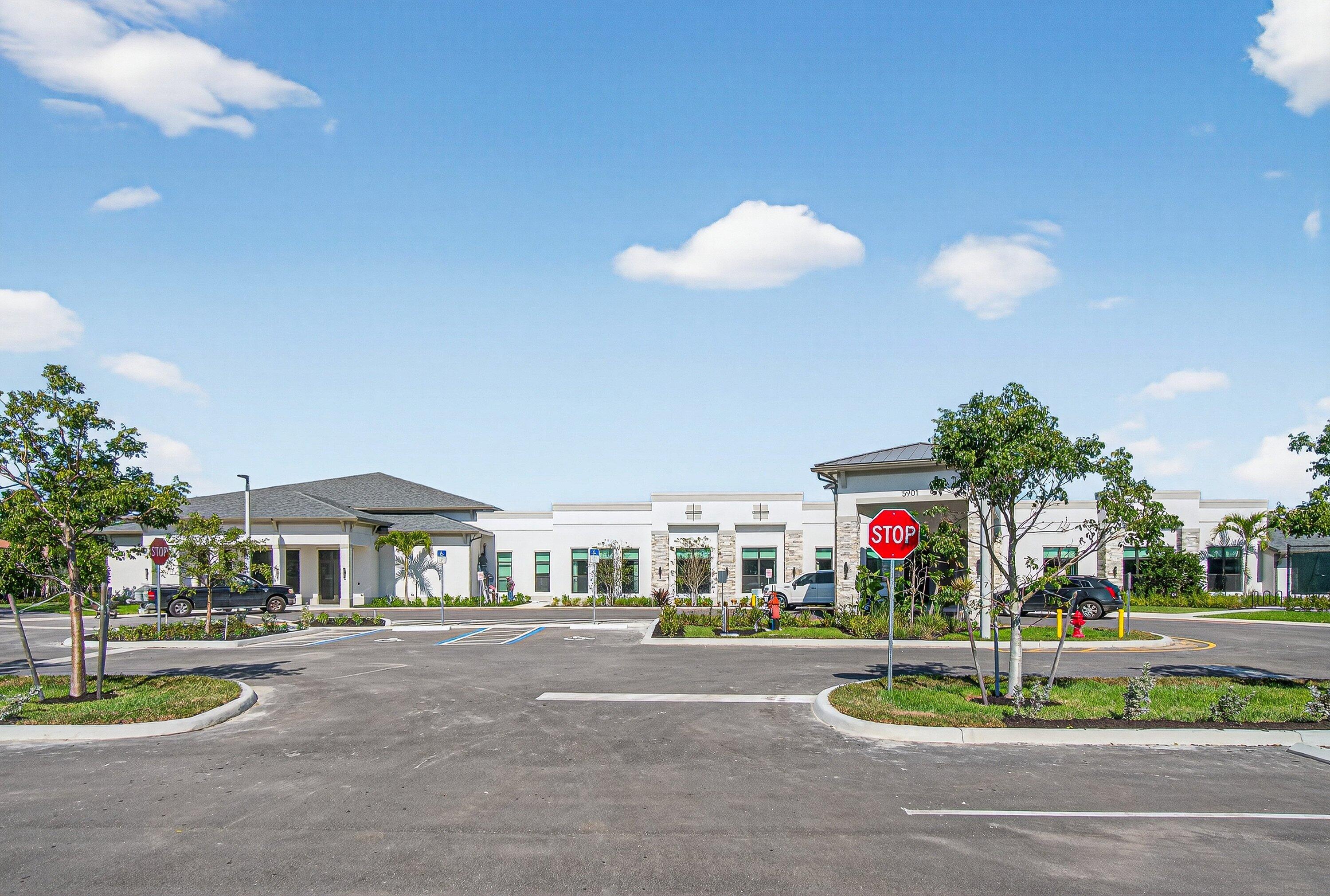 13465 Fishtail Palm Court, Unit D Delray Beach, FL 33484 - Photo 28 of 29 a front view of a house with a yard and fountain