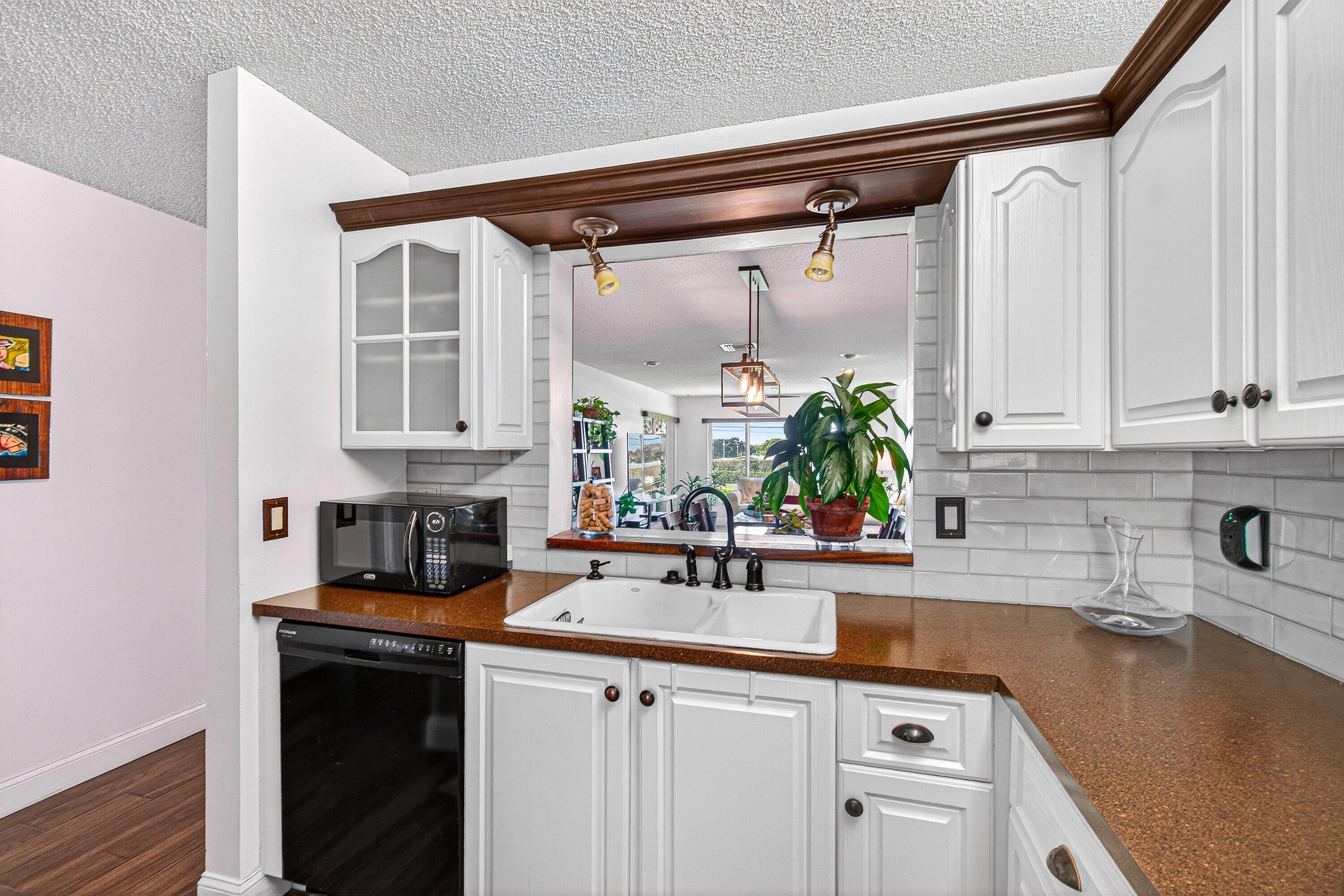 13465 Fishtail Palm Court, Unit D Delray Beach, FL 33484 - Photo 7 of 29 a kitchen with a sink stove and cabinets