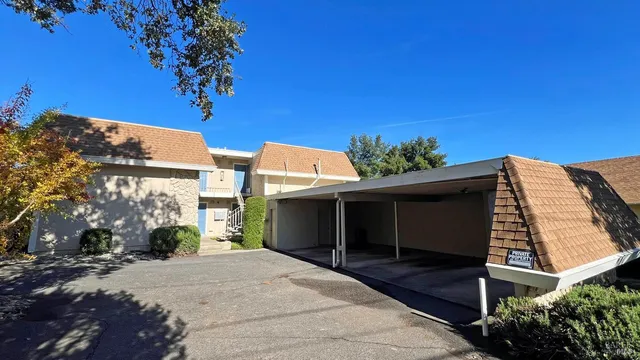 a view of a house with a yard and potted plants