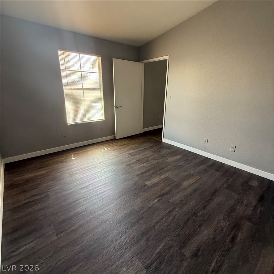1830 North Pecos Road, Unit 258 Las Vegas, NV 89115 - Photo 5 of 14 An inviting room awaits personalization with rich, dark-toned flooring.