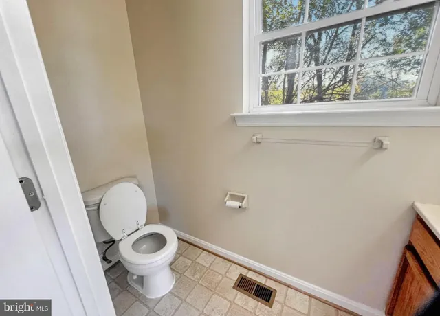 a white toilet sitting next to a window