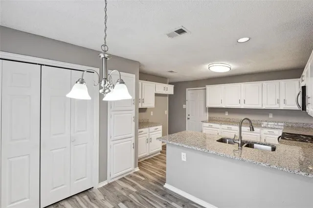 a kitchen with stainless steel appliances granite countertop a sink refrigerator and cabinets