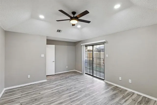 wooden floor in an empty room with a ceiling fan