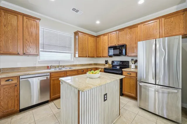a kitchen with stainless steel appliances granite countertop a refrigerator stove microwave and sink