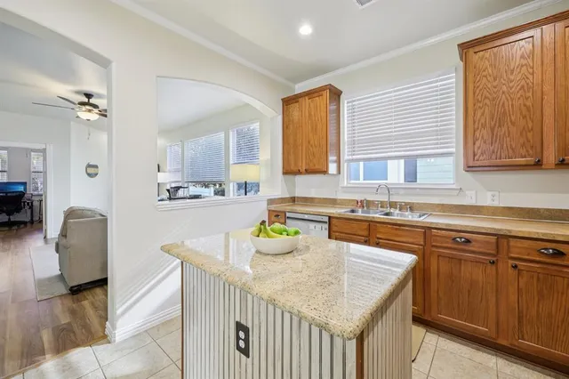 a kitchen with stainless steel appliances granite countertop a sink dishwasher stove and refrigerator with wooden floor