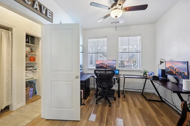 a view of a workspace with furniture and a window