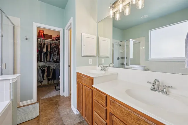 a bathroom with double vanity sinks a vanity and a large mirror