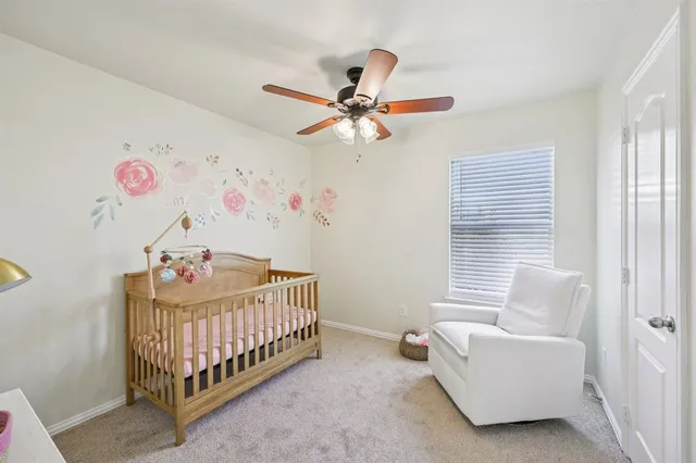 a bedroom with a baby bed a couch and a window