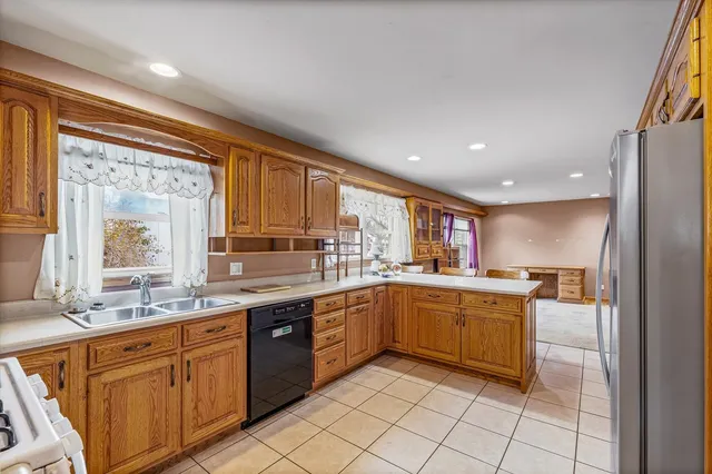 a large kitchen with granite countertop lots of white cabinets