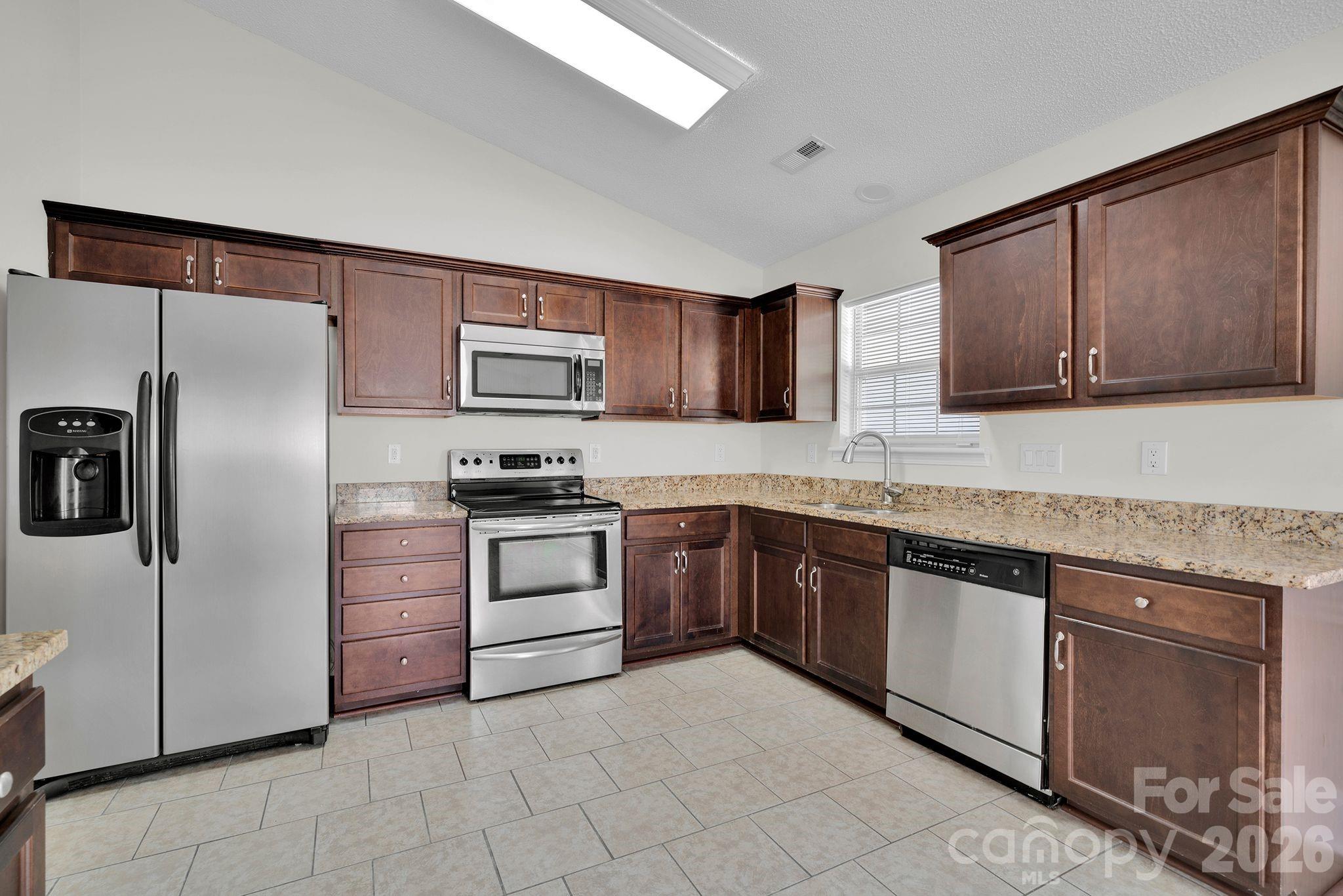 2720 Goldmine Road Monroe, NC 28110 - Photo 13 of 31 a kitchen with granite countertop cabinets stainless steel appliances and a counter space