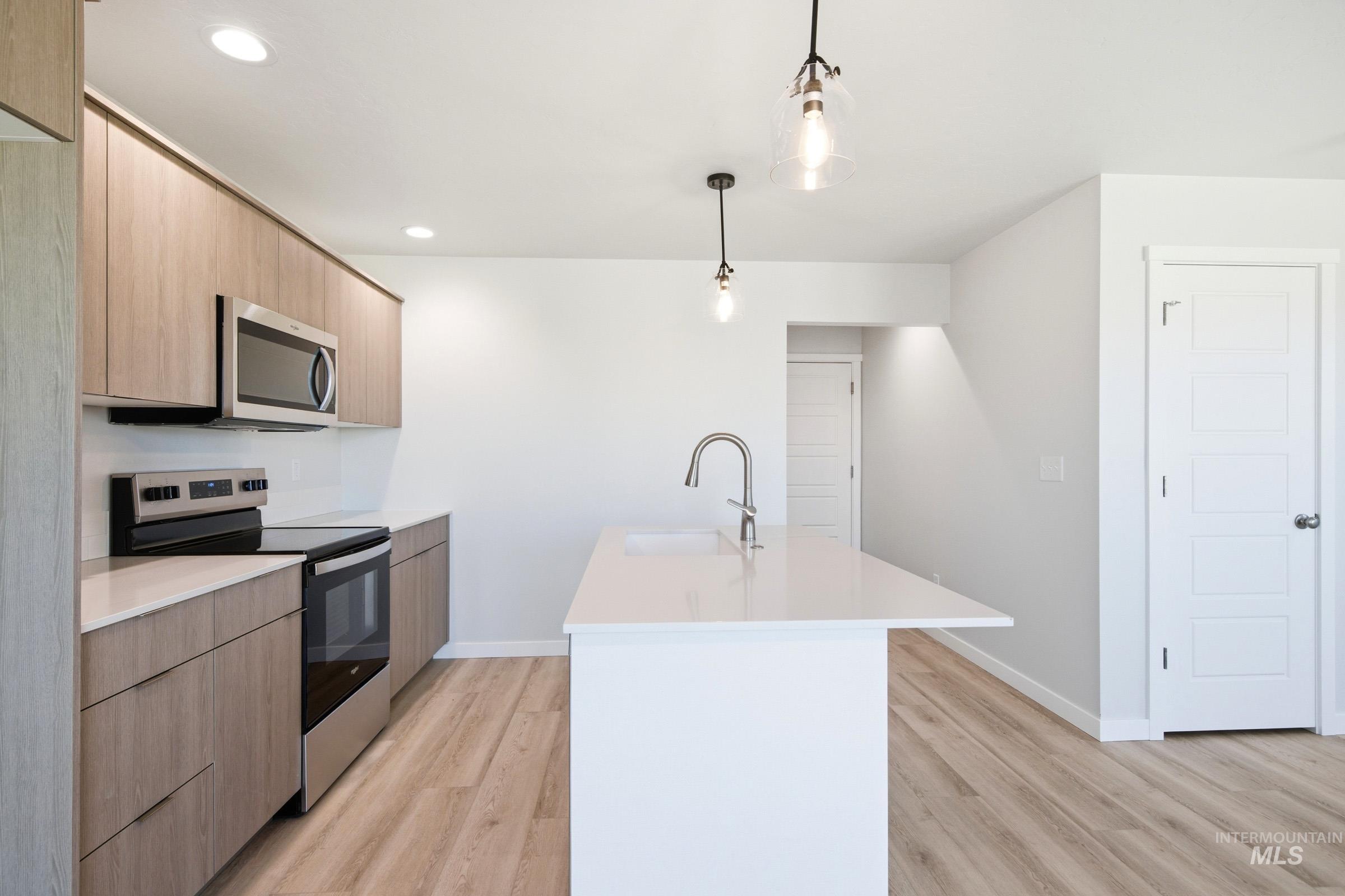 10812 Rutland Street Caldwell, ID 83605 - Photo 5 of 21 Modern kitchen featuring a central island with a built-in sink and gooseneck faucet