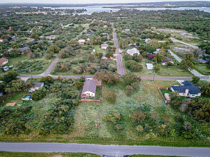 an aerial view of residential houses with outdoor space and trees
