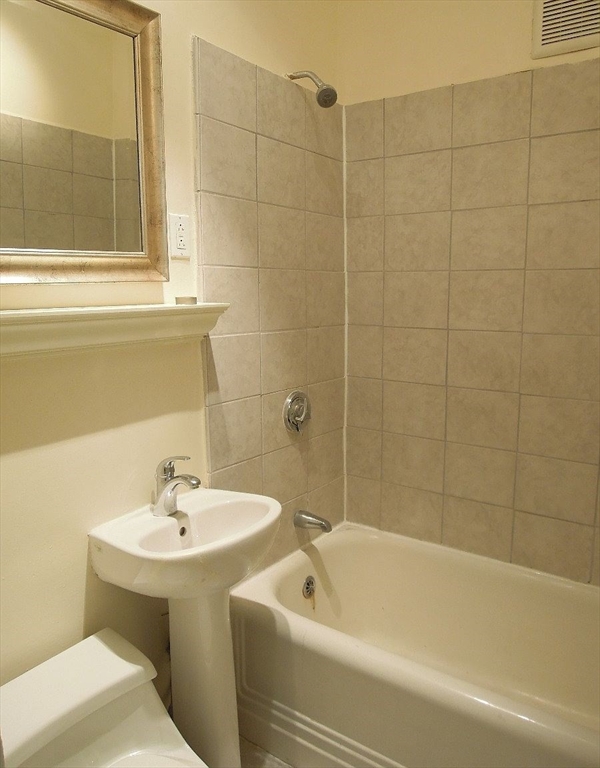 8 Garrison Street, Unit 209 Boston, MA 02116 - Photo 19 of 33 a white bath tub sitting next to a white sink and a mirror
