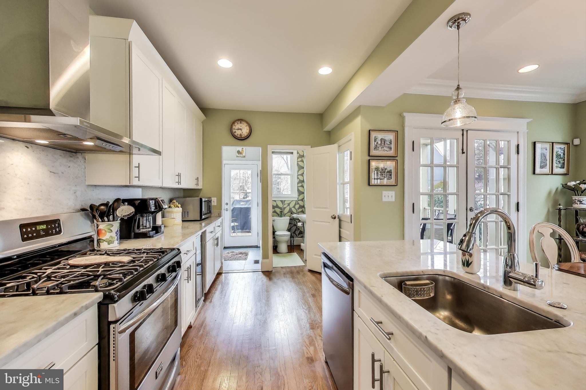 5708 4th Street Northwest Washington, DC 20011 - Photo 11 of 53 a kitchen with kitchen island granite countertop a stove a sink a refrigerator and wooden floor