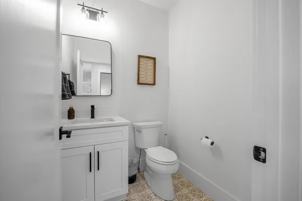 a bathroom with a toilet a sink a mirror and vanity