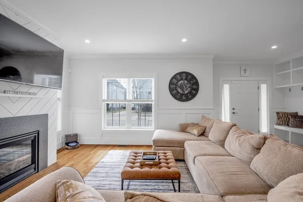 a living room with furniture a clock and a fireplace