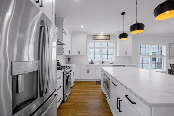 a kitchen with white cabinets and stainless steel appliances