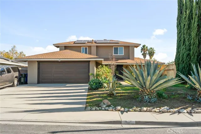 a view of a house with a small yard and potted plants