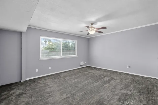 an empty room with windows and ceiling fan
