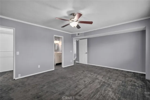 a view of an empty room with window and a ceiling fan