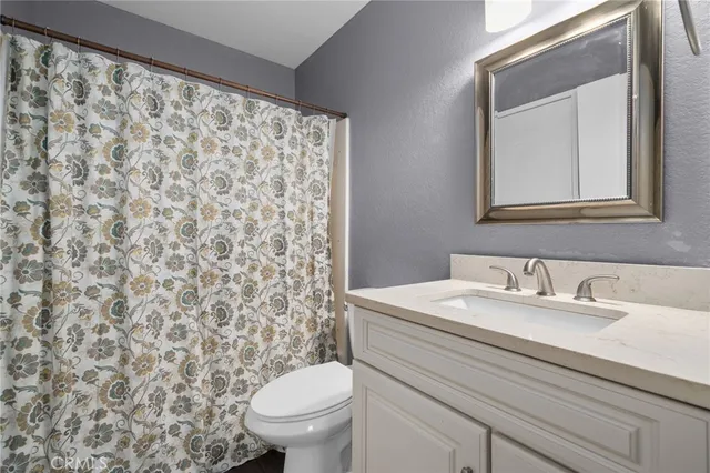 a bathroom with a sink toilet and a mirror