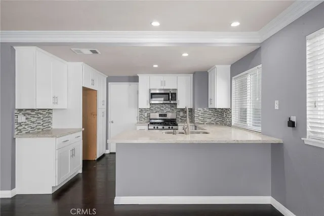 a kitchen with kitchen island a sink stainless steel appliances and cabinets