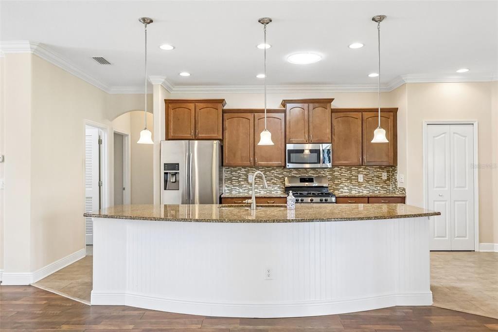 3522 Arlington Ridge Boulevard Leesburg, FL 34748 - Photo 16 of 43 a large kitchen with kitchen island a large counter top stainless steel appliances and cabinets