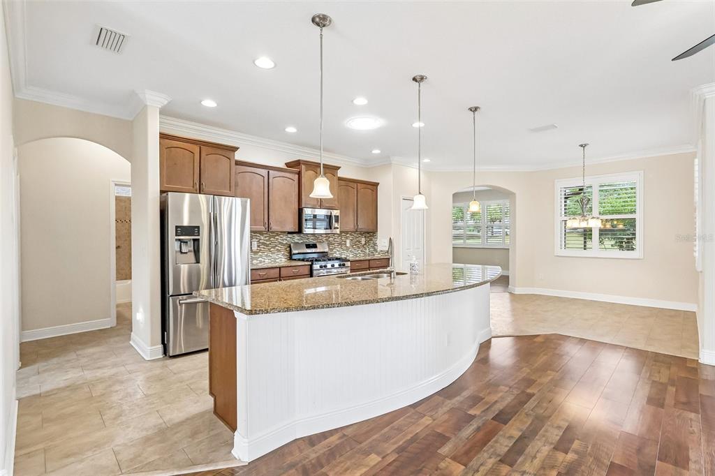 3522 Arlington Ridge Boulevard Leesburg, FL 34748 - Photo 17 of 43 a large kitchen with kitchen island a large counter top stainless steel appliances and windows