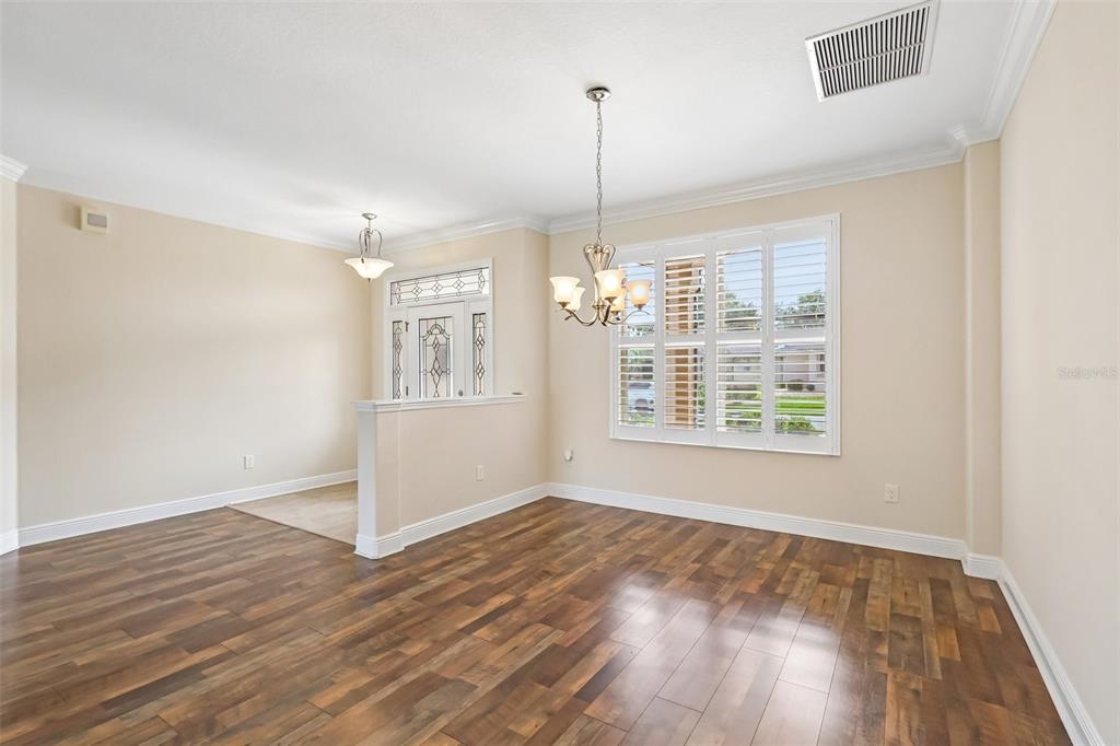 3522 Arlington Ridge Boulevard Leesburg, FL 34748 - Photo 6 of 43 a view of an empty room with wooden floor kitchen view and a window