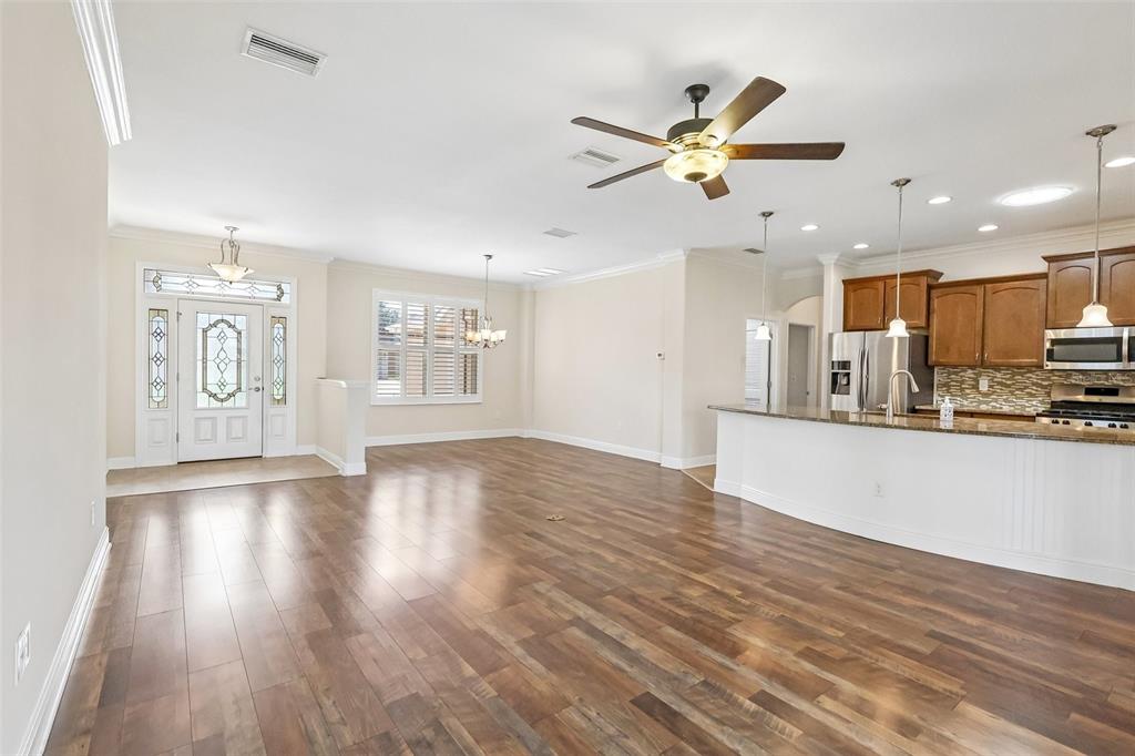 3522 Arlington Ridge Boulevard Leesburg, FL 34748 - Photo 8 of 43 a view of an empty room with kitchen appliances and a ceiling fan