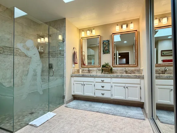 a spacious bathroom with a granite countertop sink mirror and shower