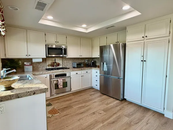 a kitchen with a refrigerator a sink a stove a microwave and cabinets