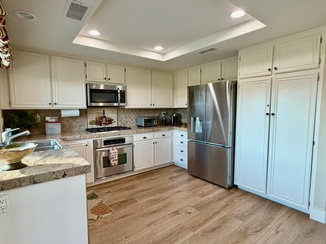 a kitchen with a refrigerator a sink a stove a microwave and cabinets
