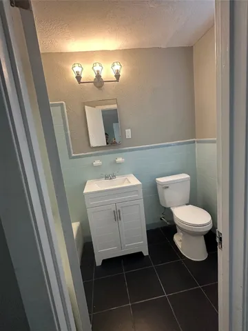 a bathroom with a toilet a sink and mirror