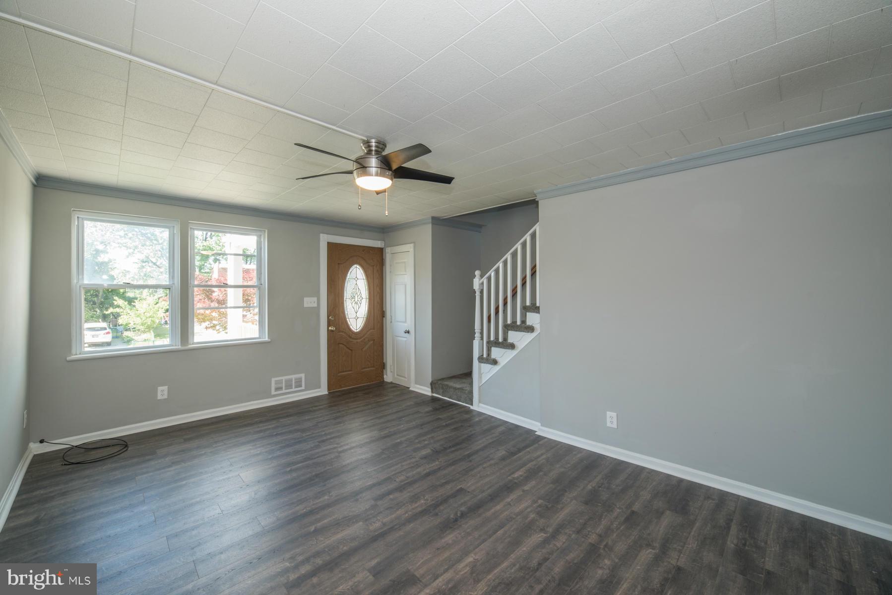 7404 Kirtley Road Baltimore, MD 21222 - Photo 2 of 13 an empty room with wooden floor and windows