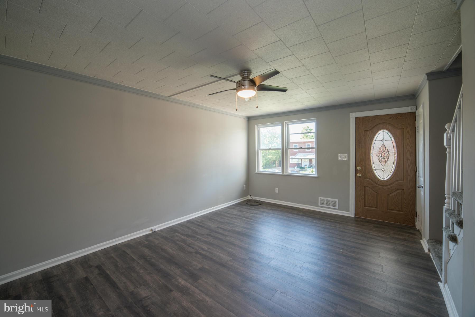 7404 Kirtley Road Baltimore, MD 21222 - Photo 3 of 13 an empty room with wooden floor and window