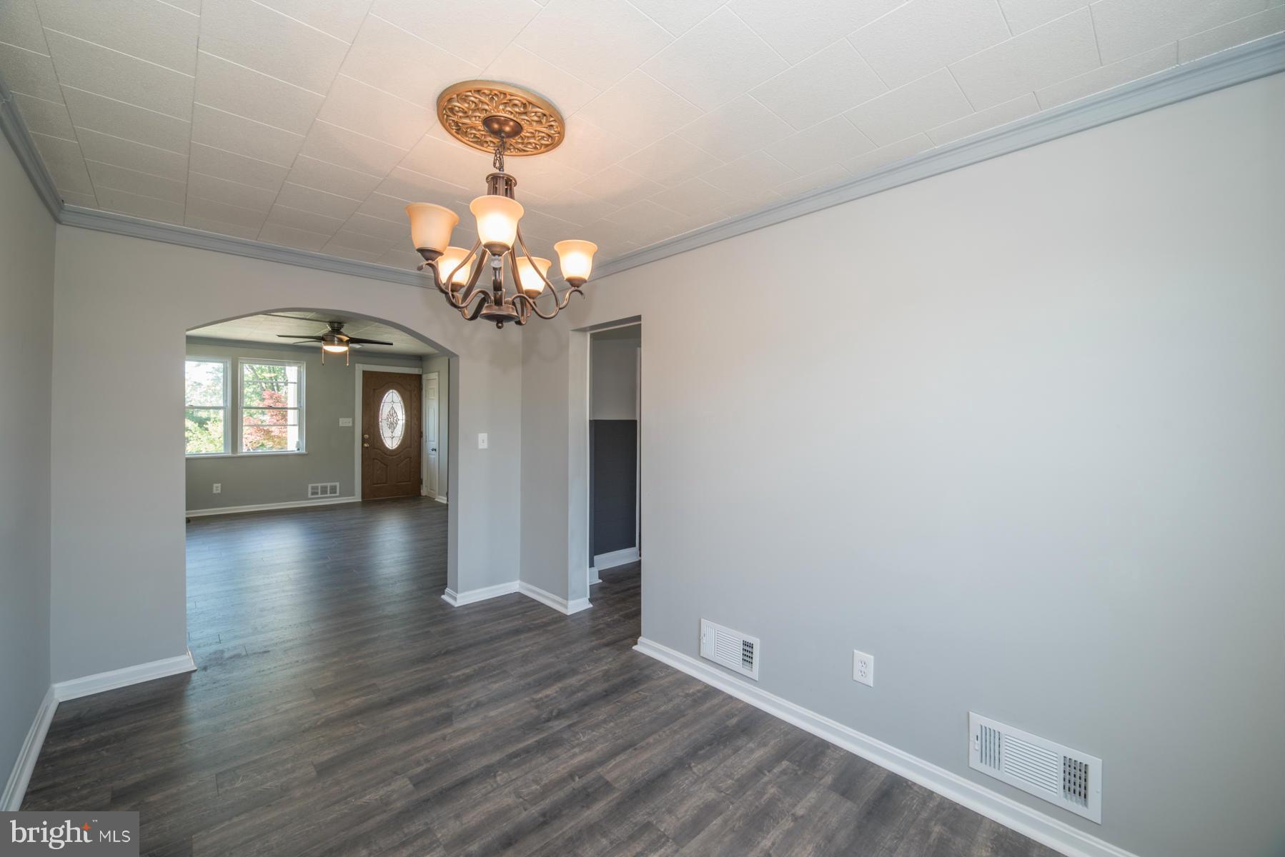 7404 Kirtley Road Baltimore, MD 21222 - Photo 6 of 13 a view of a hallway with wooden floor and a chandelier