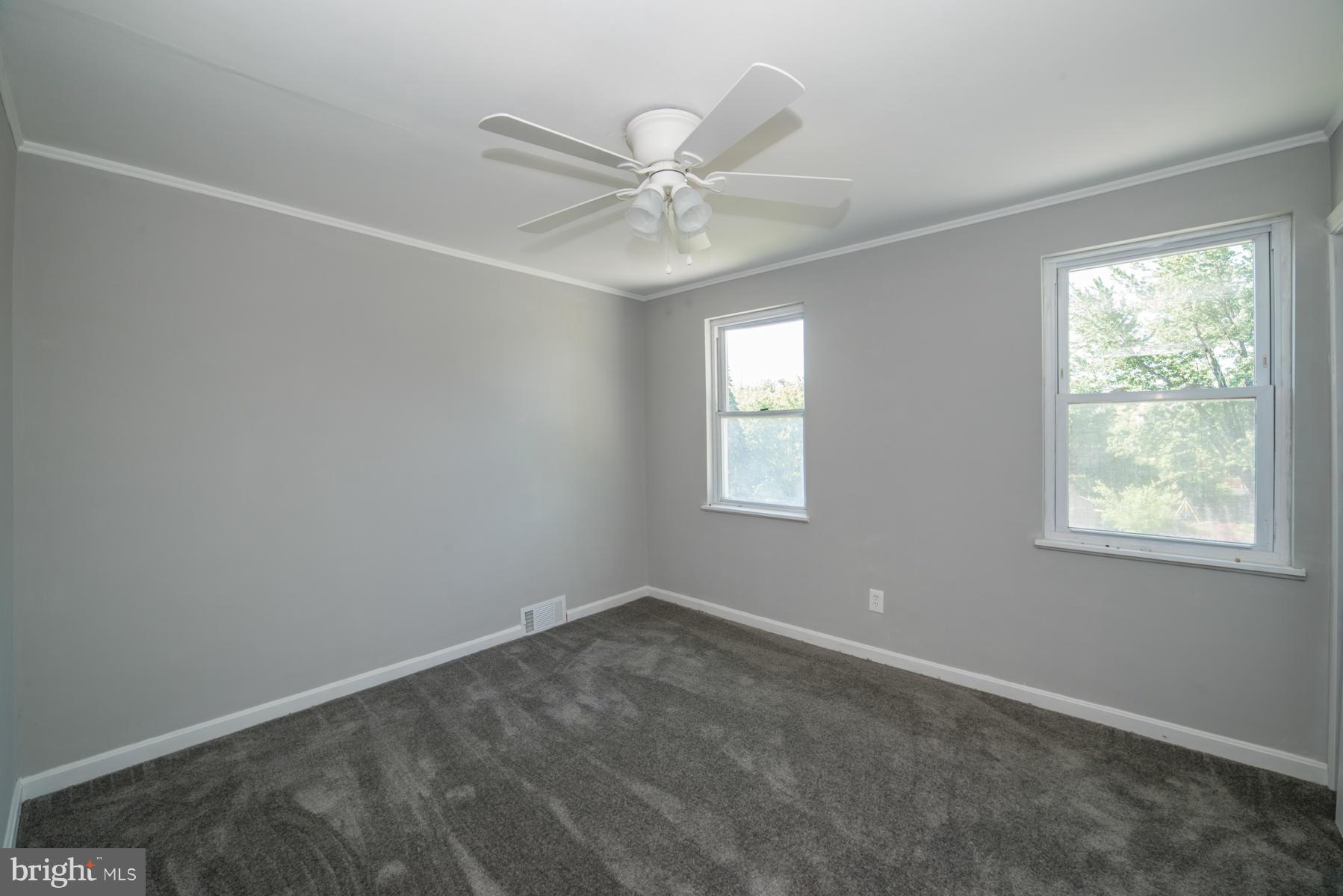 7404 Kirtley Road Baltimore, MD 21222 - Photo 9 of 13 an empty room with a window and a fan