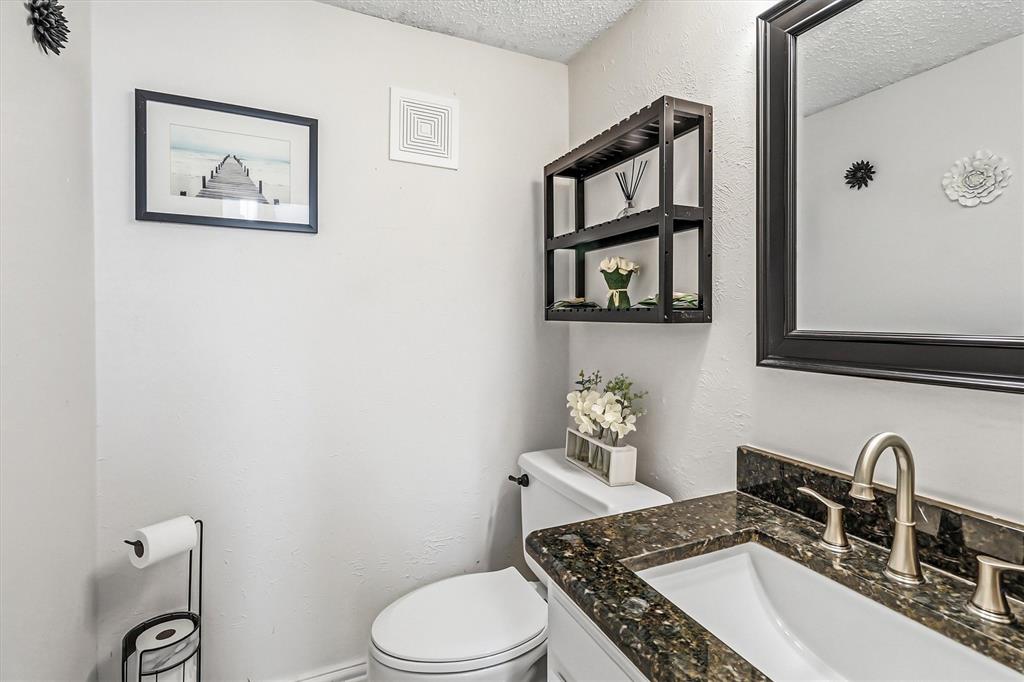 15151 Berry Trail, Unit 1307 Dallas, TX 75248 - Photo 12 of 27 Half bathroom with a textured wall, a textured ceiling, and vanity