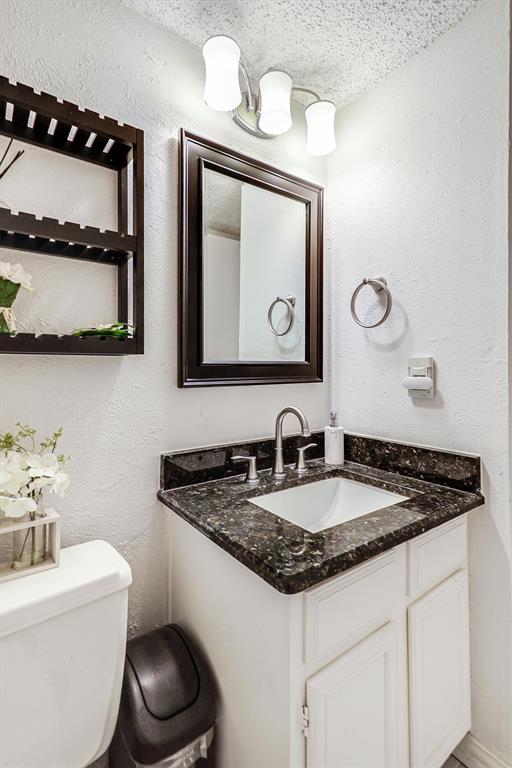 15151 Berry Trail, Unit 1307 Dallas, TX 75248 - Photo 13 of 27 Bathroom featuring a textured wall, vanity, and a textured ceiling