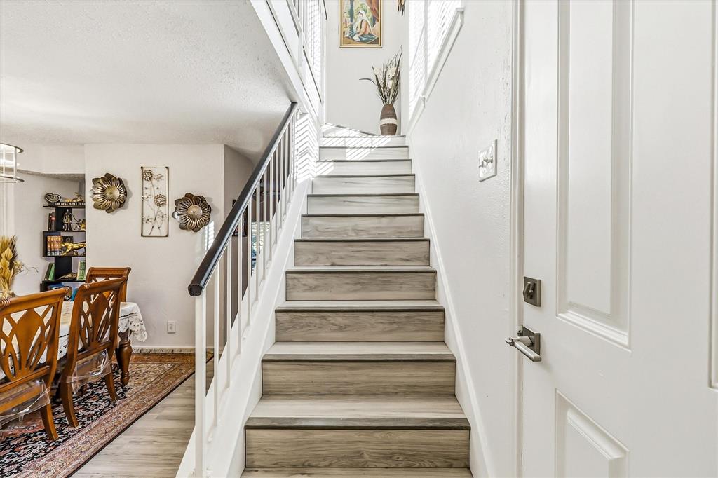 15151 Berry Trail, Unit 1307 Dallas, TX 75248 - Photo 14 of 27 Stairway with wood finished floors and a textured ceiling