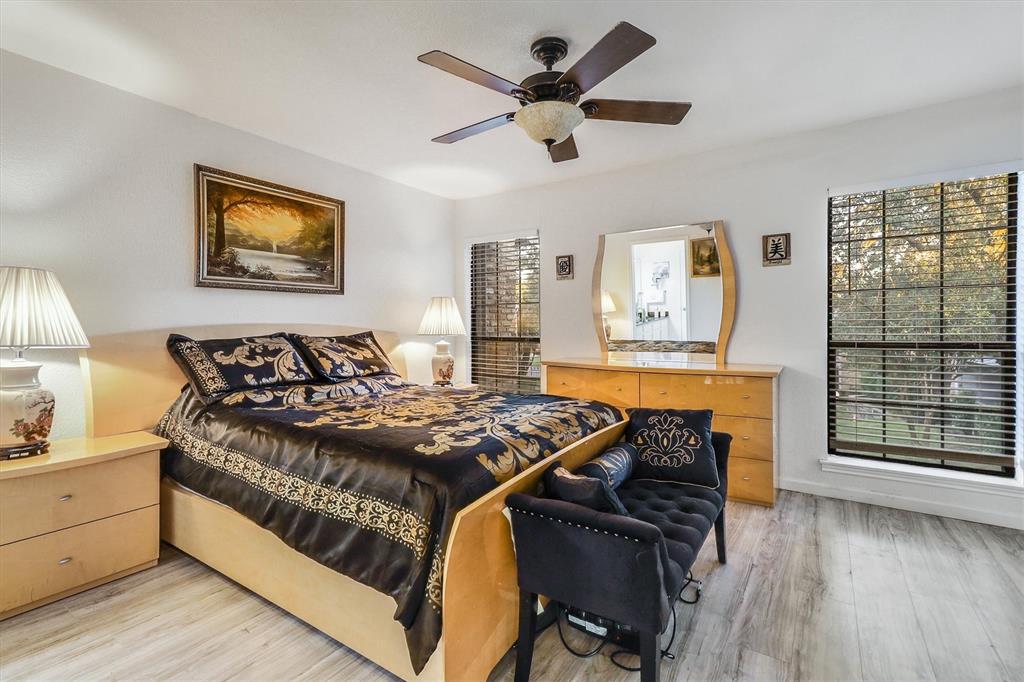 15151 Berry Trail, Unit 1307 Dallas, TX 75248 - Photo 16 of 27 Bedroom featuring multiple windows, light wood-type flooring, and a ceiling fan